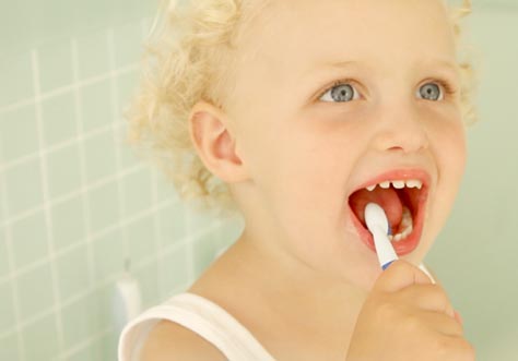 [Translate to portugese:] kid cleaning teeth